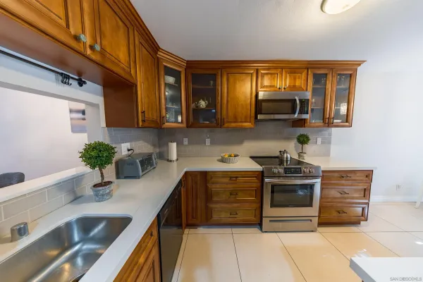a kitchen with granite countertop a sink stainless steel appliances and cabinets