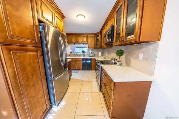 a kitchen with stainless steel appliances a refrigerator a sink a stove and cabinets