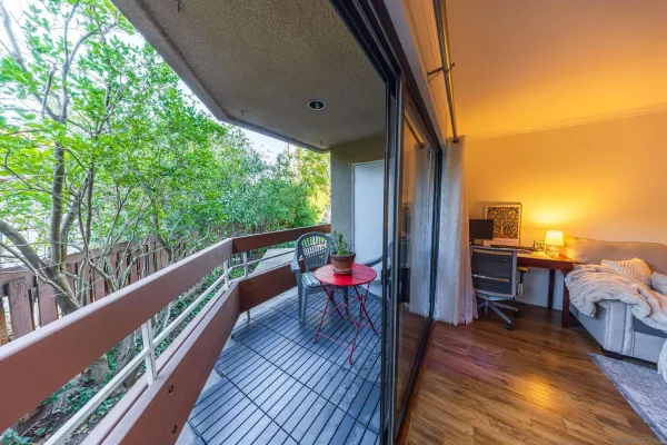 a balcony with wooden floor table and chairs
