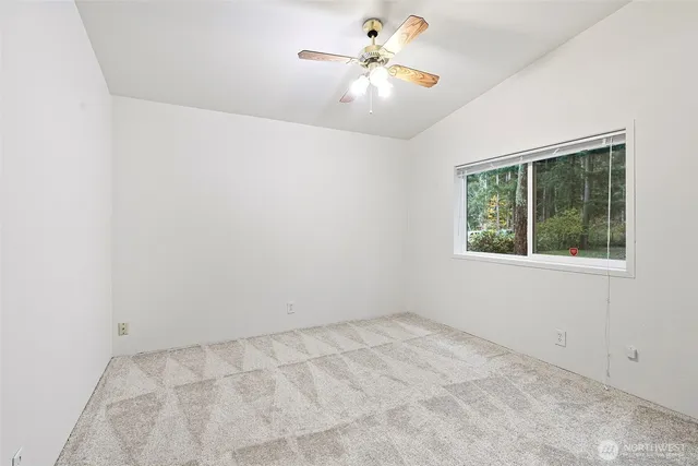 an empty room with a window and a fan