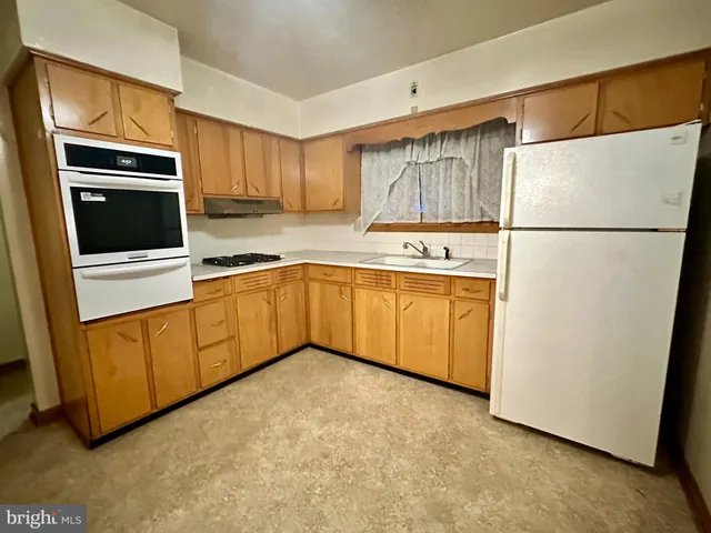 a kitchen with stainless steel appliances granite countertop a refrigerator a stove a sink and a microwave