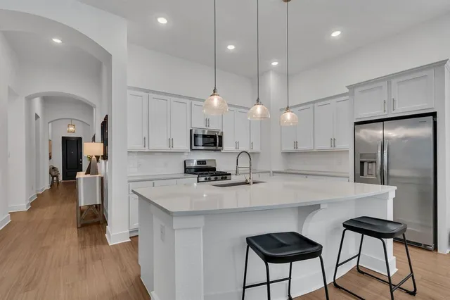 a kitchen with kitchen island a counter space a sink appliances and cabinets