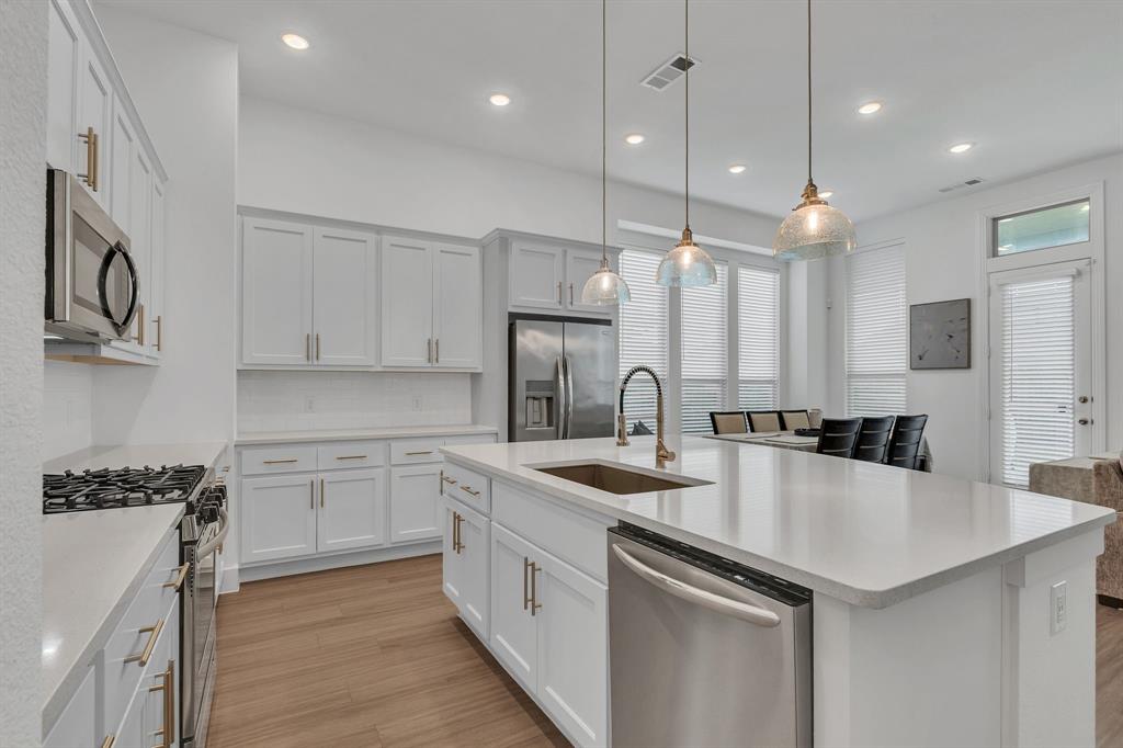 1817 Lockhart Drive Forney, TX 75126 - Photo 14 of 32 a kitchen with a sink a stove a refrigerator and white cabinets