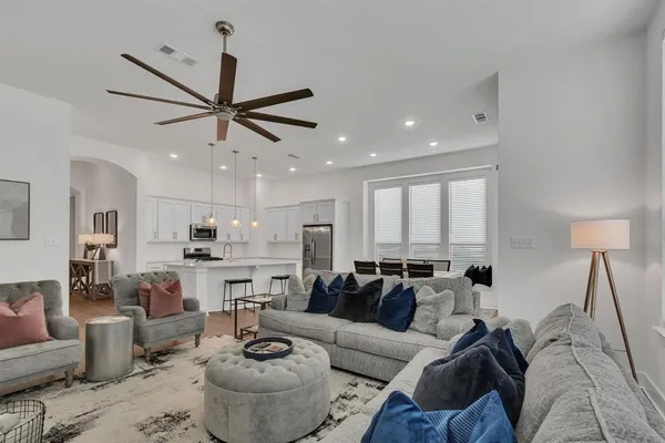 a living room with furniture kitchen and a chandelier