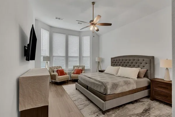 a bedroom with a bed a flat screen tv and a couch