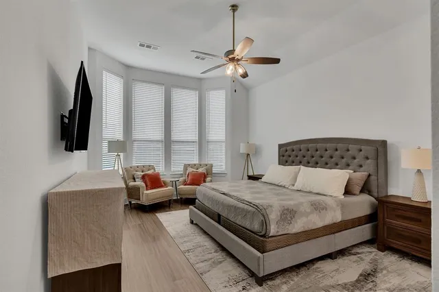 a bedroom with a bed a flat screen tv and a couch