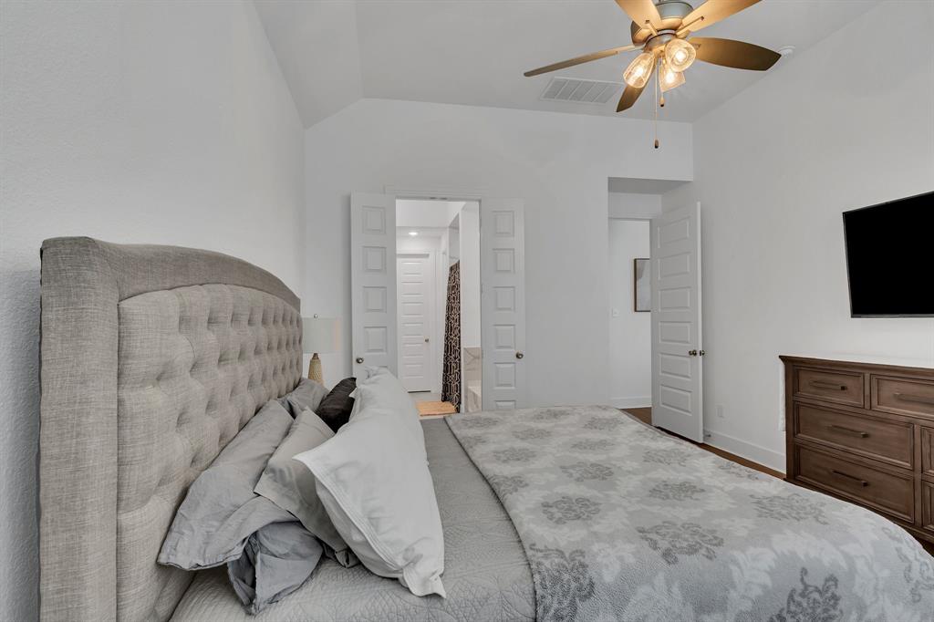 1817 Lockhart Drive Forney, TX 75126 - Photo 22 of 32 a bedroom with a bed and a flat screen tv