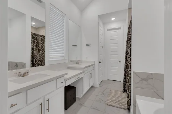 a spacious bathroom with a double vanity sink a mirror and a bathtub