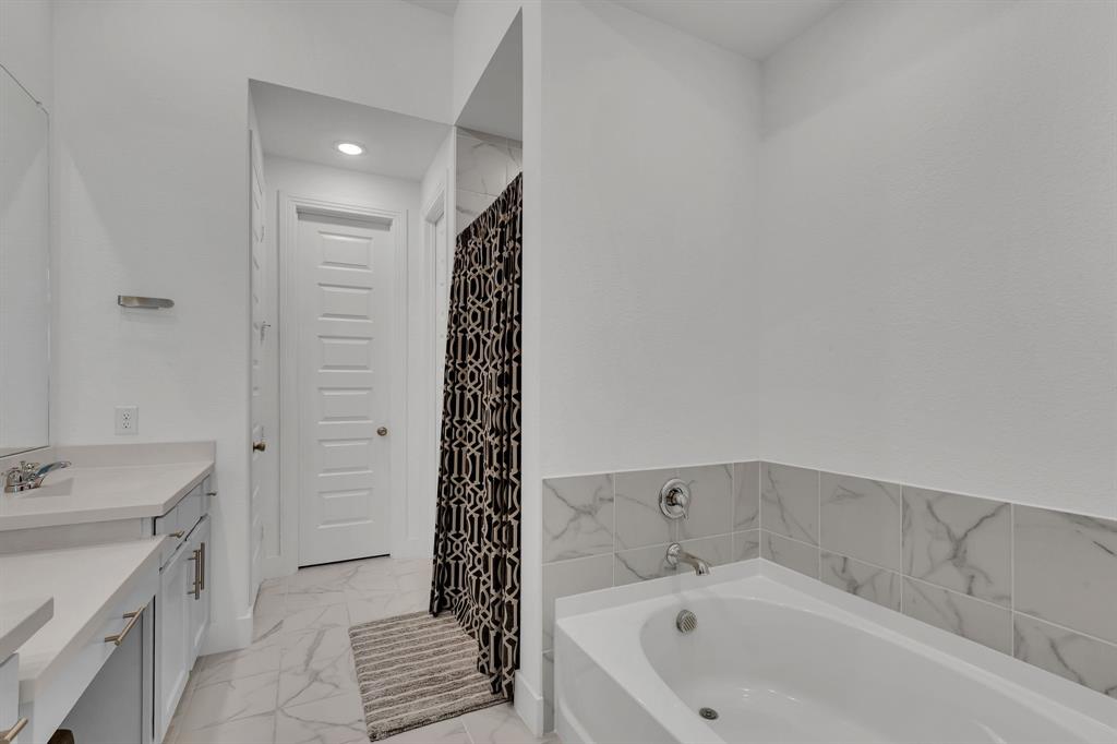 1817 Lockhart Drive Forney, TX 75126 - Photo 24 of 32 a bathroom with a bathtub and a sink