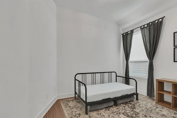 a view of a hallway with wooden floor and a window