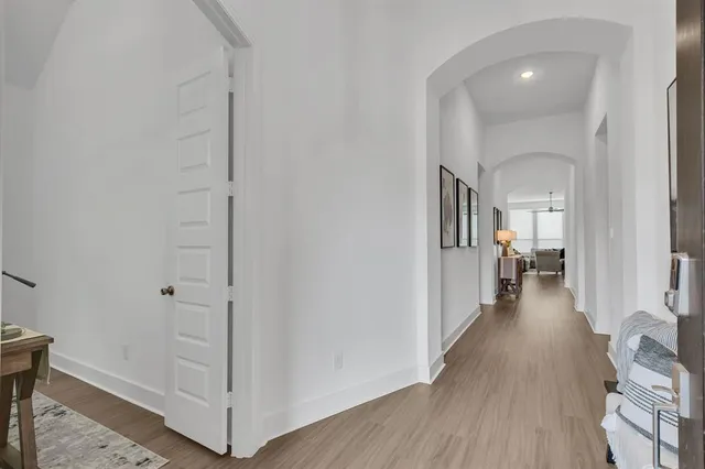 a view of a hallway with wooden floor and staircase