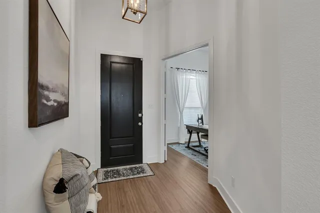 a view of a hallway with wooden floor and closet