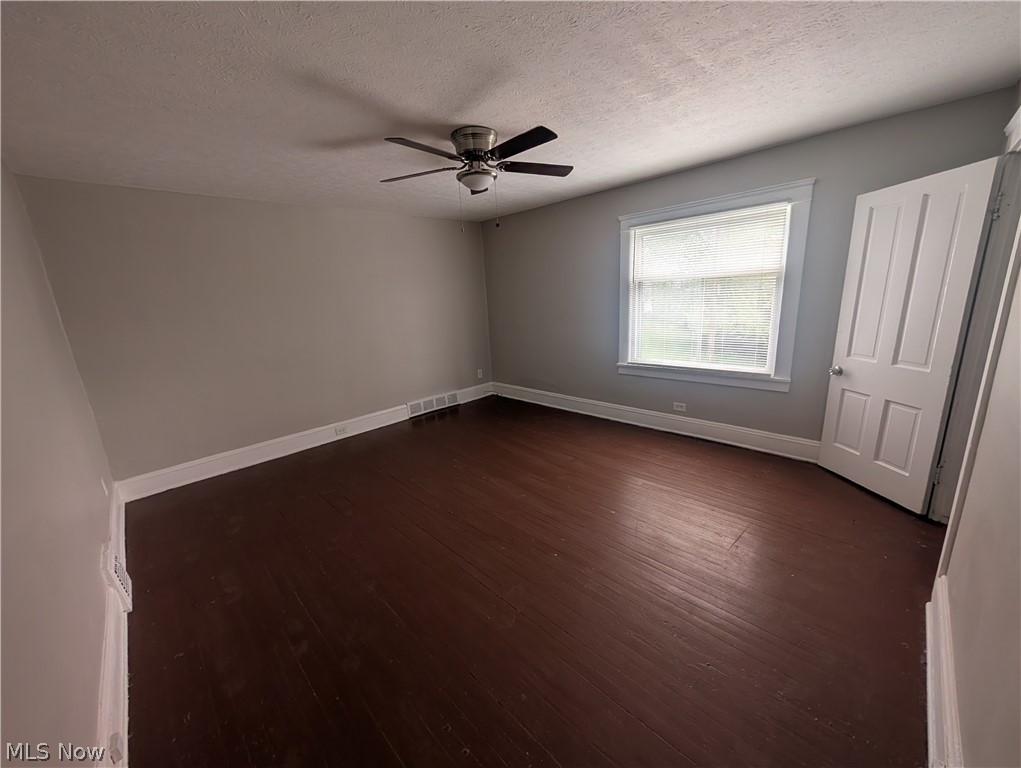 7515 Ottawa Road Cleveland, OH 44105 - Photo 9 of 21 Spacious room featuring wood-finish flooring, light grey walls, white trim, and a ceiling fan