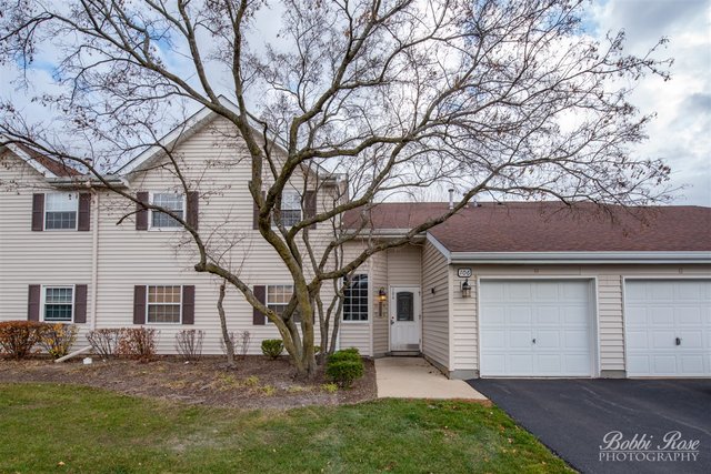 106 Gant Circle, Unit G Streamwood, IL 60107 - Photo 1 of 12 a view of a yard in front of a house with large tree