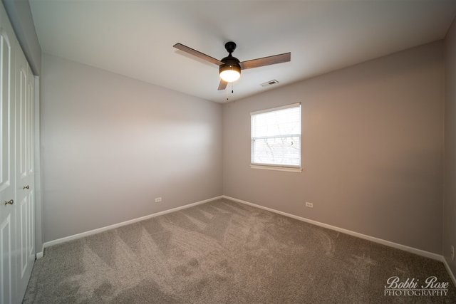 106 Gant Circle, Unit G Streamwood, IL 60107 - Photo 11 of 12 an empty room with a window and a ceiling fan