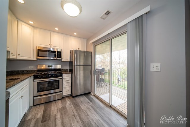 106 Gant Circle, Unit G Streamwood, IL 60107 - Photo 4 of 12 a kitchen with stainless steel appliances granite countertop a refrigerator a stove a sink and a microwave