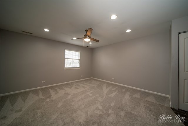 106 Gant Circle, Unit G Streamwood, IL 60107 - Photo 6 of 12 a view of an empty room with a window