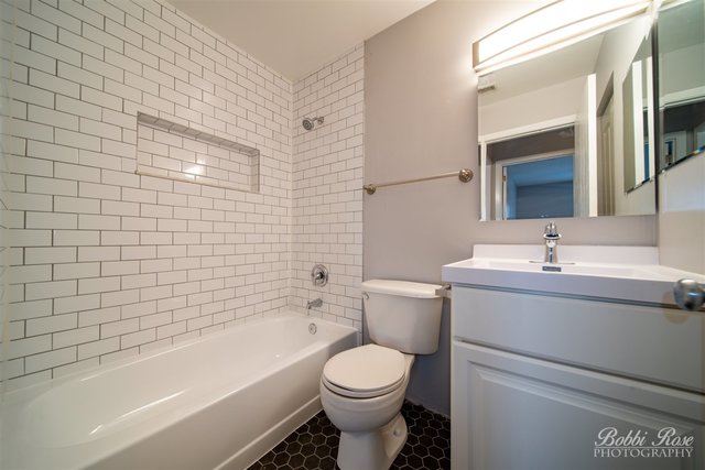 106 Gant Circle, Unit G Streamwood, IL 60107 - Photo 7 of 12 a bathroom with a toilet a sink a mirror and bathtub