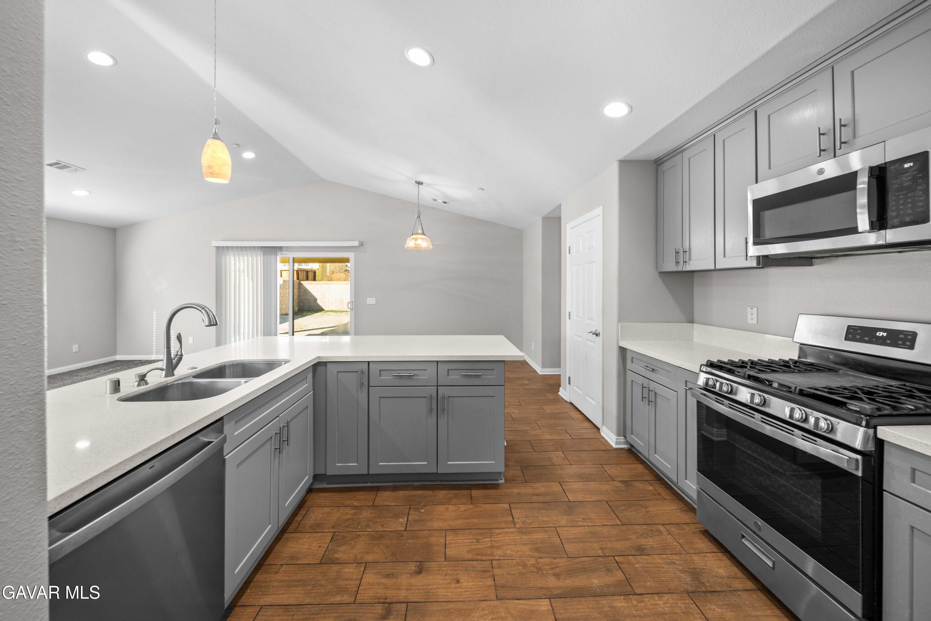 2009 Jenner Street Lancaster, CA 93535 - Photo 6 of 15 a large kitchen with stainless steel appliances granite countertop a stove a sink dishwasher and a microwave oven with white cabinets
