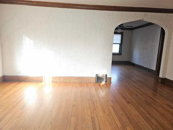 a view of a room with wooden floor and a window