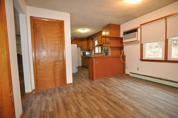an empty room with wooden floor and a window