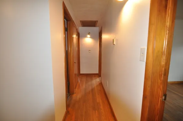 a view of a hallway with wooden floor