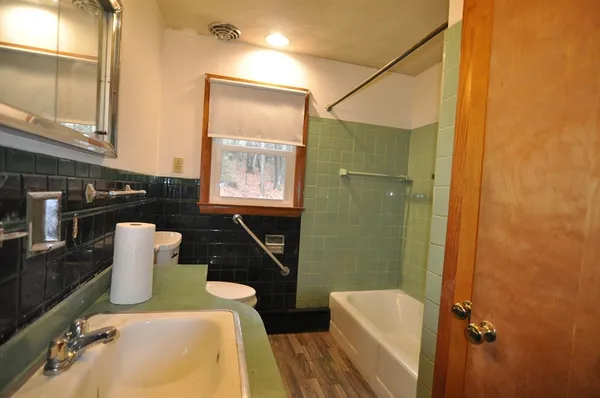 a bathroom with a sink toilet and mirror