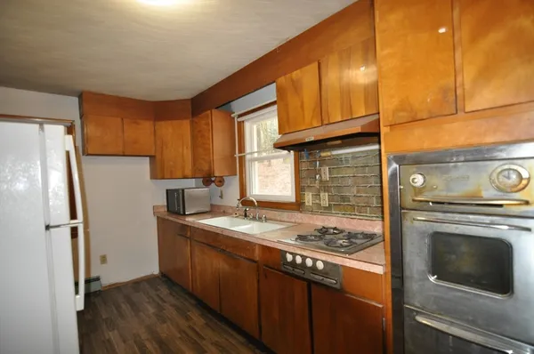 a kitchen with a stove a refrigerator and cabinets