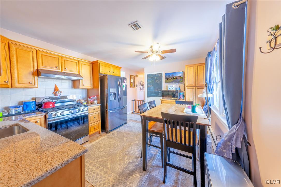 70 Colonial Road Allentown, PA 18109 - Photo 9 of 32 a kitchen with a stove a refrigerator and a dining table with wooden floor