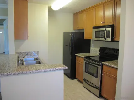 a kitchen with stainless steel appliances granite countertop a refrigerator stove and oven