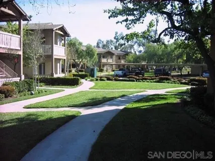 a view of a house with a big yard and large trees