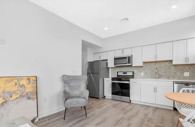 a kitchen with stainless steel appliances kitchen island granite countertop a refrigerator oven a stove top oven a sink and dishwasher