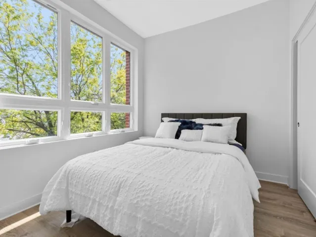 a large bed sitting in a bedroom next to a window