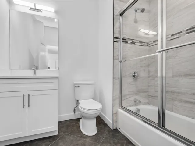 a bathroom with a granite countertop toilet sink and shower