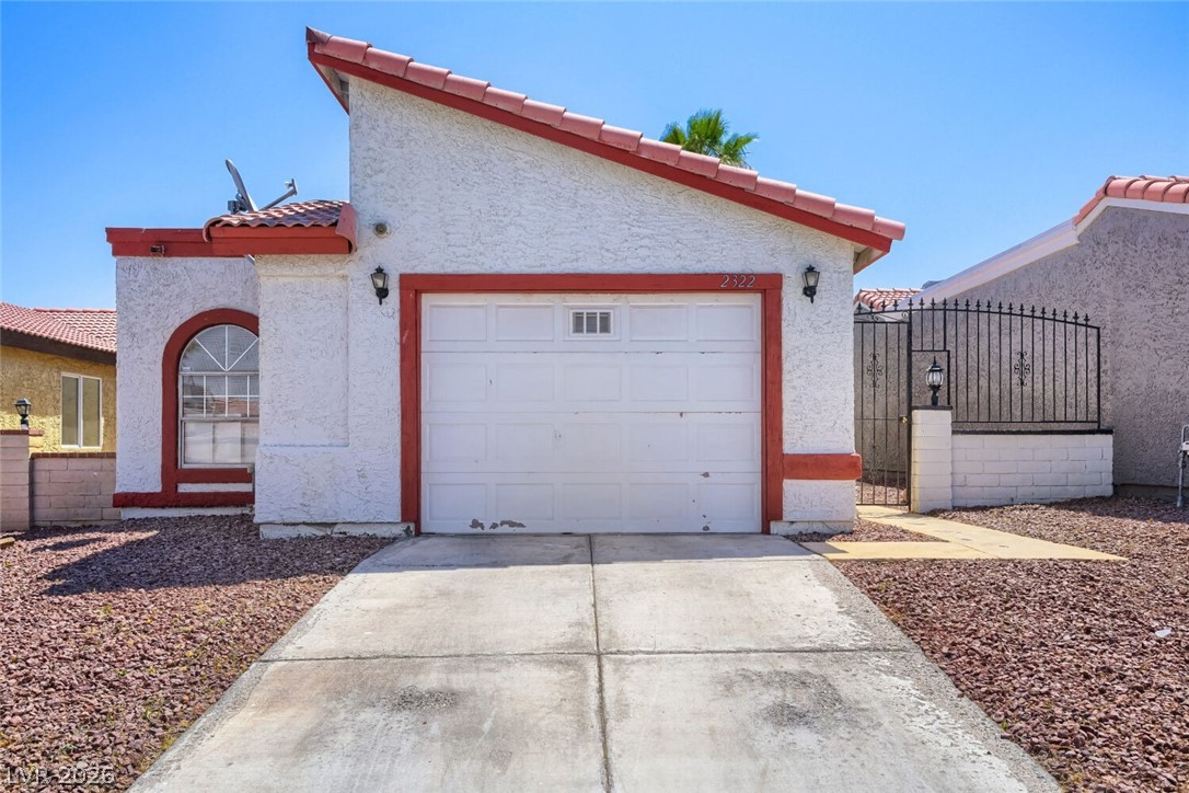 2322 Sabroso Street Las Vegas, NV 89156 - Photo 3 of 17 A well-maintained facade with a garage and a decorative arched window.