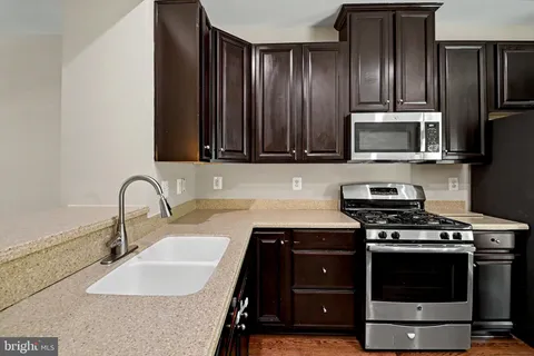 a kitchen with a sink and a stove top oven
