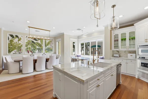 a dining room with furniture a chandelier and kitchen view