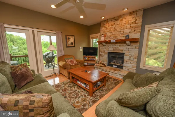 a living room with furniture a large window and a fireplace
