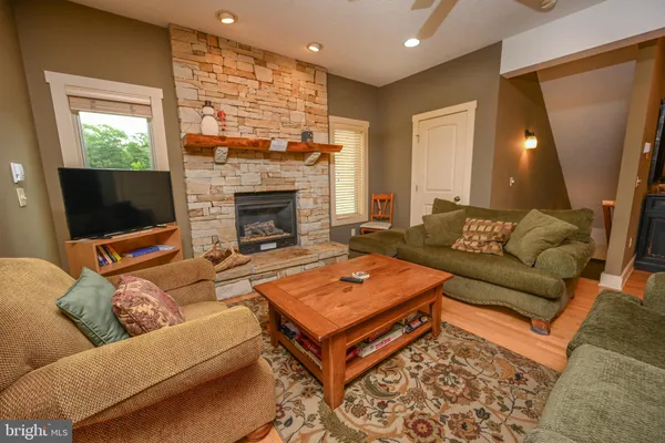 a living room with furniture a flat screen tv and a fireplace