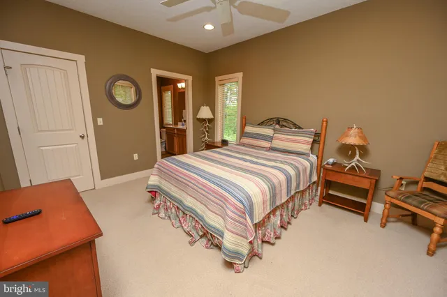 a spacious bedroom with a bed and a lamp with the table