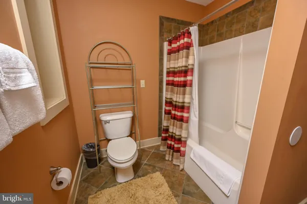 a bathroom with a toilet and a shower curtain