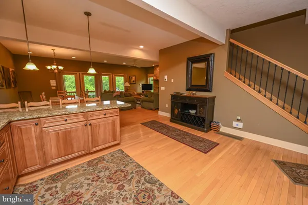 a open kitchen with stainless steel appliances granite countertop a stove a sink and a microwave