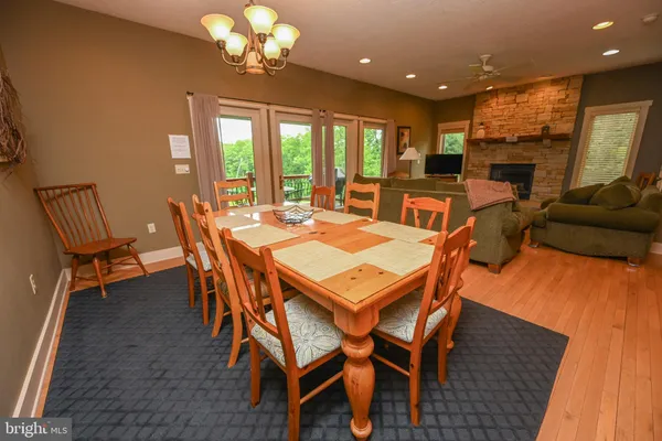 a view of a dining room with furniture a chandelier and wooden floor