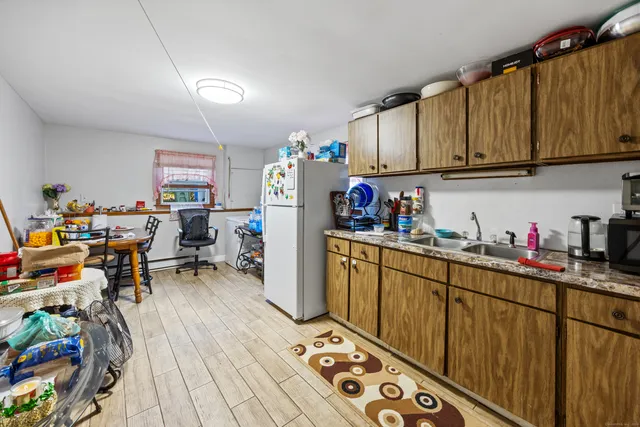 a kitchen with granite countertop lots of clutter and stainless steel appliances