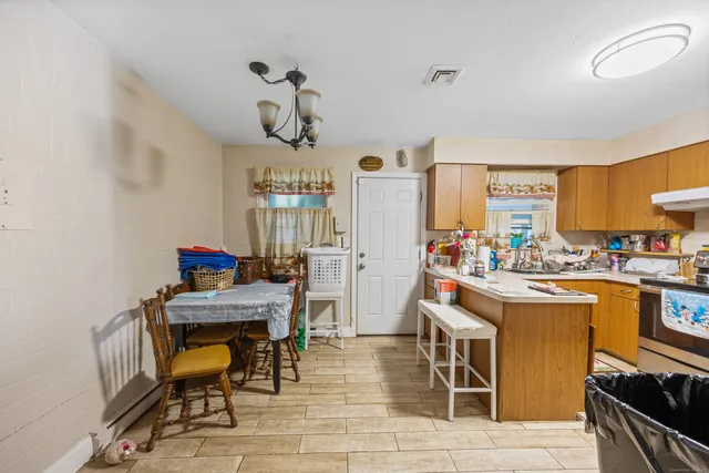 a kitchen with stainless steel appliances kitchen island granite countertop a table and chairs in it