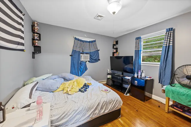 a bedroom with a bed and wooden floor