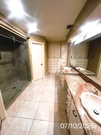a bathroom with a tub shower vanity and a sink