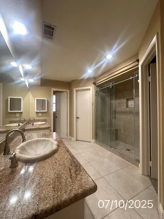 a bathroom with a granite countertop sink and a mirror