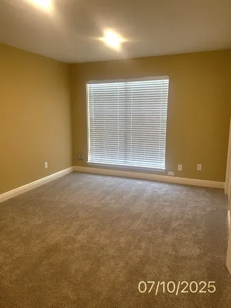 a view of a livingroom with an empty space and a window