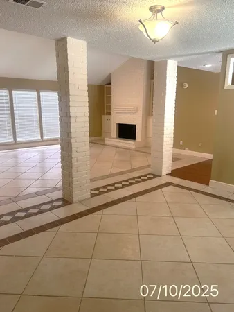 a view of a refrigerator in kitchen and an empty room